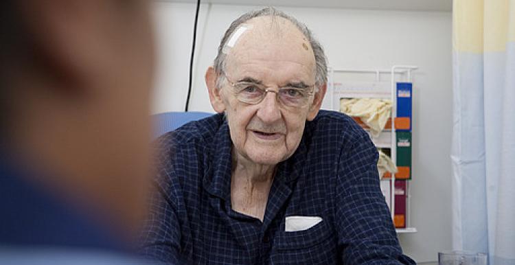 Male patient sitting in a chair on hospital ward