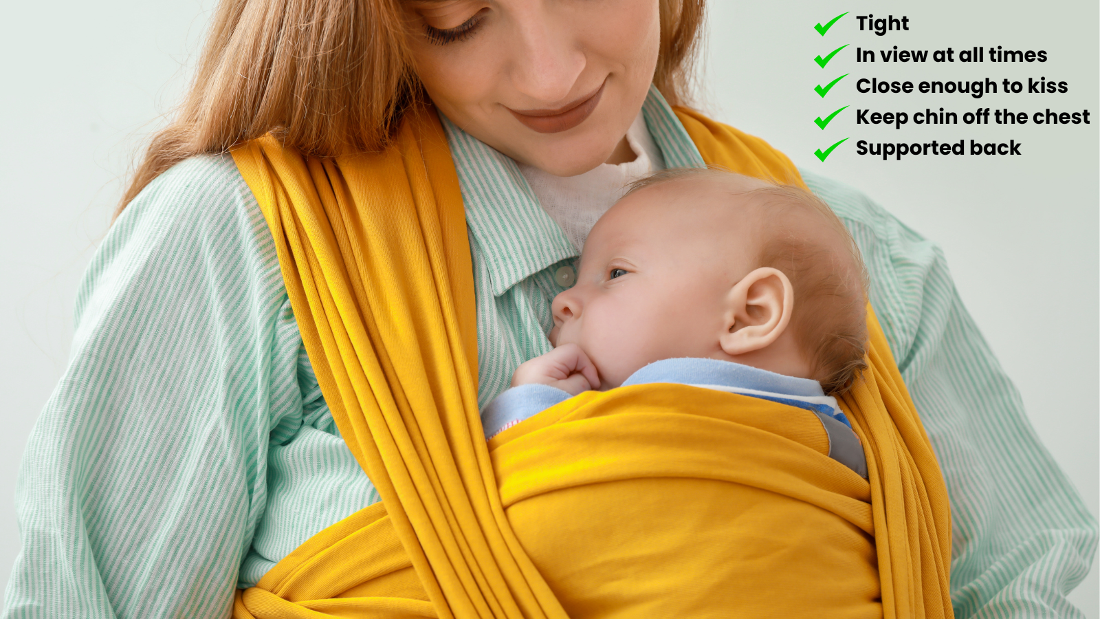 A mother wearing a yellow baby sling while cradling her infant, ensuring proper babywearing safety with key points listed: tight, in view at all times, close enough to kiss, keeping the chin off the chest, and supporting the baby's back. The baby is nestled comfortably against the mother, looking peaceful and secure.