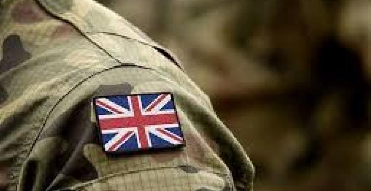 Armed forces Union Jack emblem, on camouflaged uniform. 