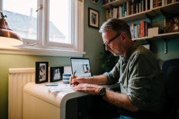 older male working at a desk in home office