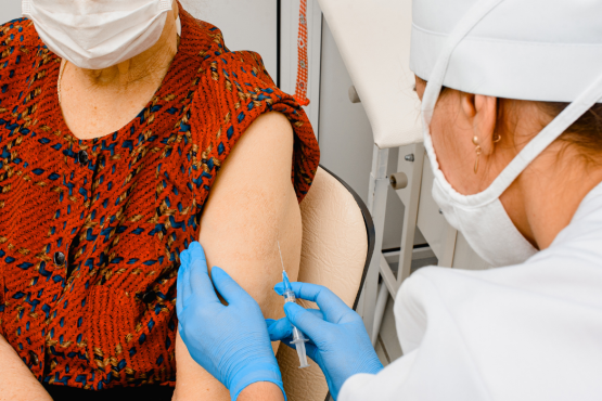 doctor getting ready to carry out a vaccination on a female patient