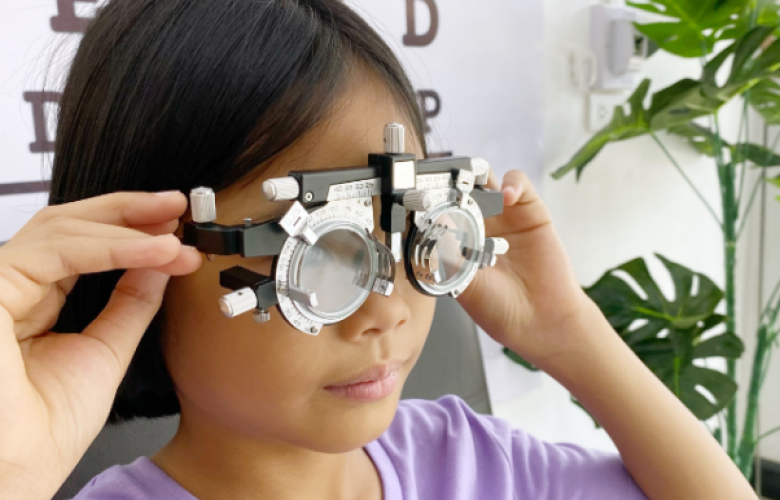 A child looks through eye test lenses. 